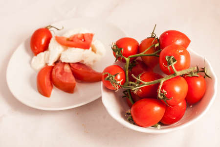 Italian Buffalo mozzarella cheese and red tomatoes on a white backgroundの写真素材