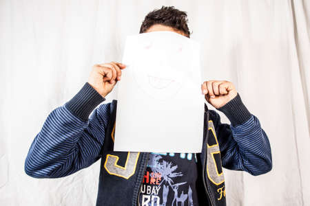 Young dark haired boy photographed in the studio with white backgroundの写真素材