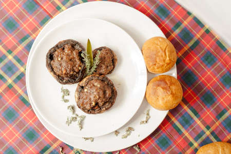 Mushrooms stuffed with meat and bread on a tablecloth Scottishの写真素材