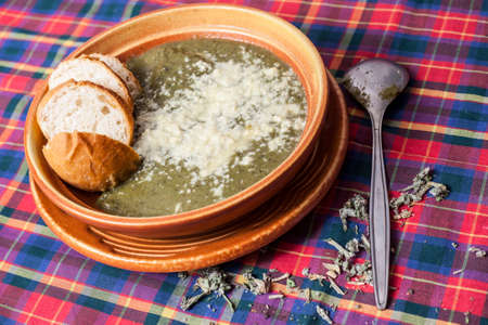 Vegetable soup with bread, parmesan cheese in a rustic ceramic potの写真素材