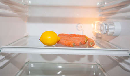 Only a lemon and carrots in a refrigeratorの写真素材