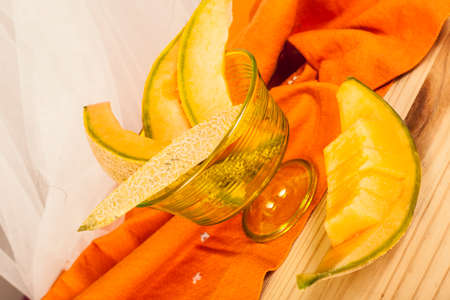 Melon slices in a cup of green plasticの写真素材