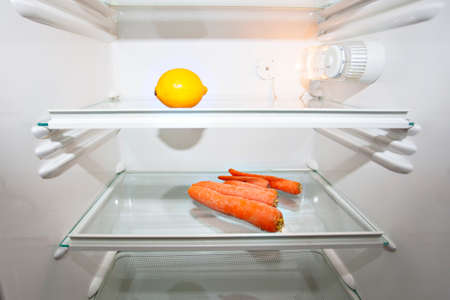 Only a lemon and carrots in a refrigeratorの写真素材