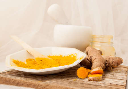 Composition shabby studio, dust and the root of turmeric, white background.