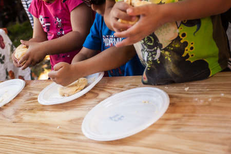 Summer kids' camp ,loaves in plastic plates on a wooden table on a farm.の写真素材