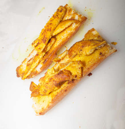 Healthy chicken breast sandwich cooked with turmeric on white background.