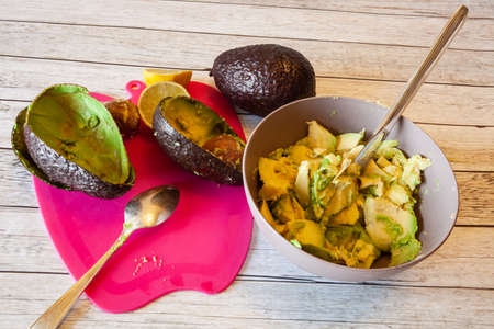 Preparation of Mexican guacamole sauce, flash light.