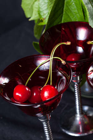 Small organic cherries freshly picked from the tree in spring on a black backgroundの写真素材