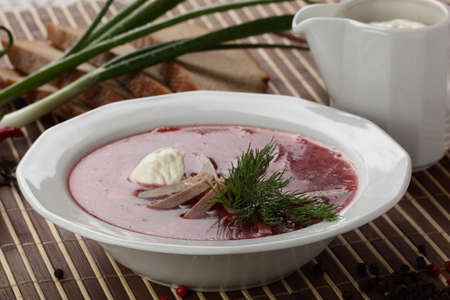 Cold and fresh soup with meat on the wooden table
