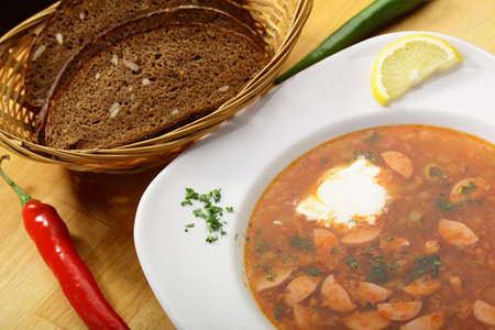 tasty and hot soup with sausages and lemonの写真素材