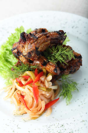 chicken legs and salad on white dishの写真素材