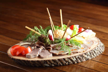 fresh peaces of meat with garnish on wooden tableの写真素材