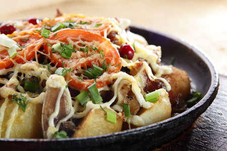 Fried potato with pepper on black pan