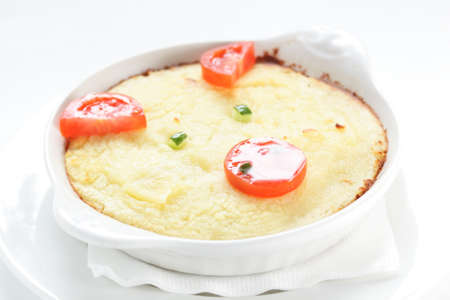 cold roasted potato with tomatoes on white dishの写真素材