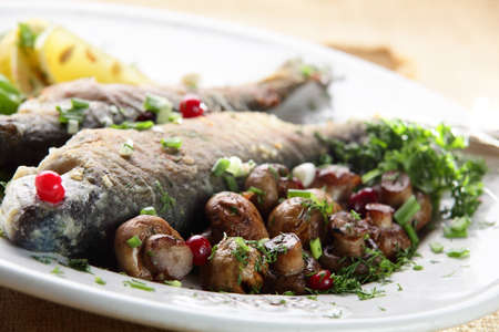 roasted and hot fish mith vegetables and mushroomsの写真素材