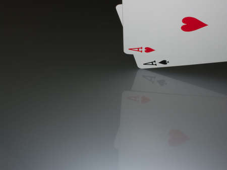 Aces on a reflective surface and dark background.の写真素材