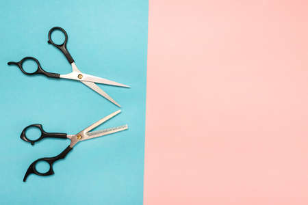 Professional hair cutting tools, scissors. Colored background blue and pink.の写真素材