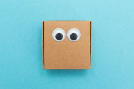 Craft box with eyes. Box for moving. Square Emoji made of paper. Funny paper cubes with eyes.の写真素材