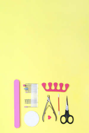 Set for manicure and pedicure. Caring for your nails. Beauty concept. Yellow background. Flat lay. Vertical. Text.の写真素材