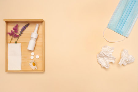 Seasonal allergy. Spring bloom allergy. Nasal spray medical mask flower and pills. Flat lay. Copy...