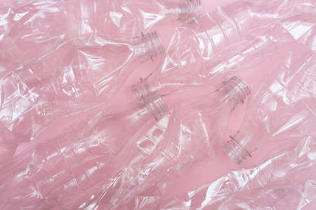 Lost of used crumpled plastic bottles on pink background. Conservation of nature. Recycling concept. Rumpled. Reasonable consumption.の写真素材