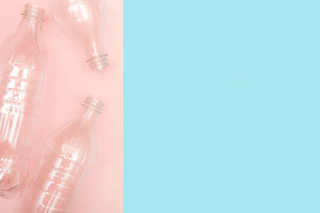 Empty used plastic bottles on blue and pink background with place for text. Copy space. Recycling concept. Reusing. Ecology problems. Flat lay.の写真素材