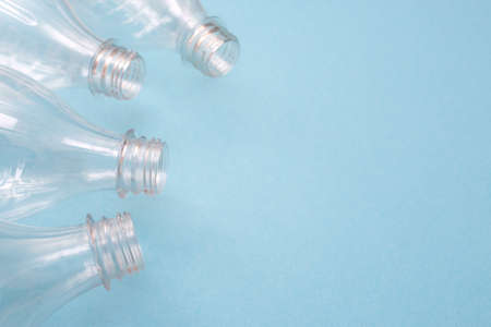 Empty used plastic bottles on blue background with place for text. Copy space. Recycling concept....