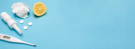 Banner. Catch a cold. Flu season. Disease. Flat lay. Medical mask, pills, nasal spray, thermometer, and lemon tea. Place for your text. Copy space. Mockup. Seasonal cold concept. Health care.の写真素材