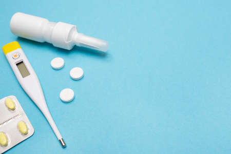 Catch a cold. Flu season. Disease. Pills, nasal spray, thermometer, and antibiotics. Place for your text. Copy space. Mockup. Seasonal cold concept. Health care.の写真素材