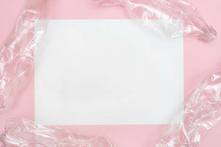 Used and crumpled plastic bottles on pink background with a place for text. Recycling concept. Rumpled. Reasonable consumption. Flat lay. Copy space.の写真素材