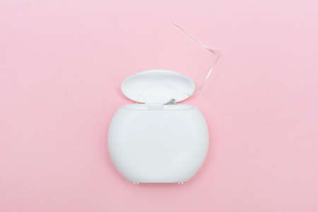 Dental floss on a pink background. Caring for dental healthの写真素材