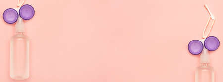 Banner with accessories for contact lenses care. Solution, container, tweezers and suction cup for contact lenses. Hygienic kit for vision. Place for your text. Copy space. Pink backgroundの写真素材