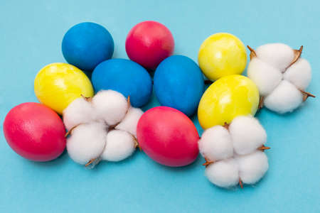 Easter composition. Colored eggs blue, yellow and red on a blue background. flat lay. top view....