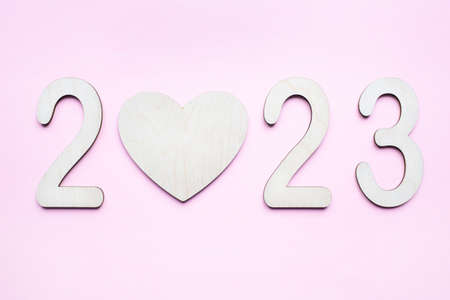 New Year 2023. Pink background. flat lay. top view. Empty wooden heart. new year concept.の写真素材