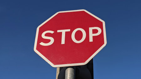 Stop sign on blue sky background. Red sign with the inscription stop.