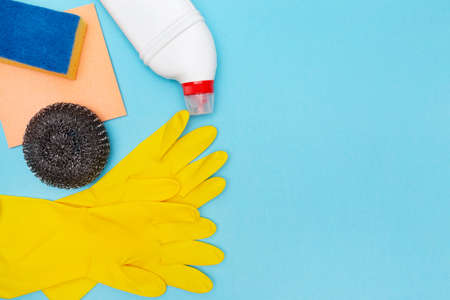 Tools and accessories for cleaning home, kitchen and office. cleaning service. Place for text and label. copyspace. blue background. Rubber gloves, sponge and detergent. Cleanliness concept.の写真素材