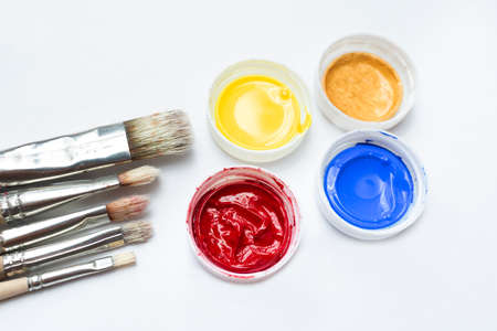 Brushes and different acrylic paints on a white background. Home leisure and hobby. Painting courses.の写真素材