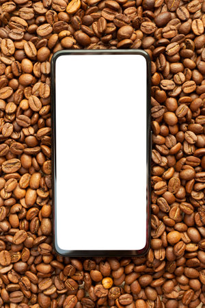 Roasted coffee beans and phone with white screen. Place for your text and label. mockup. Top view, flat lay. copyspace. Advertisement for coffee shop or storeの写真素材