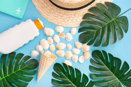 Summer holidays with seashells, palm leaves and straw hat. Blue background. Top view, flat lay.
