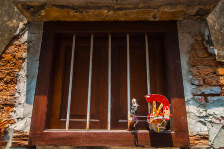 doll with wagon in front of a door