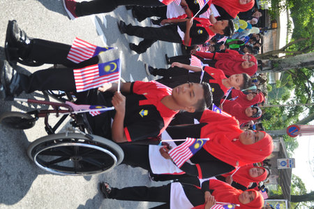 GEORGE TOWN, MALAYSIA - AUGUST 31, 2016 : Student waving Malaysia flag also known as Jalur Gemilang...