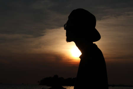 Silhoutte of a man infront of sunsetの写真素材