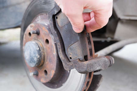 Car repair. Replacing the brake pads of disc brakes. Brake disc close-up.の写真素材