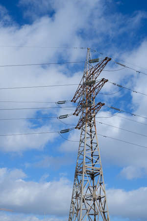 High voltage power line. View of the metal support of the power transmission line against the background of the blue sky.の写真素材
