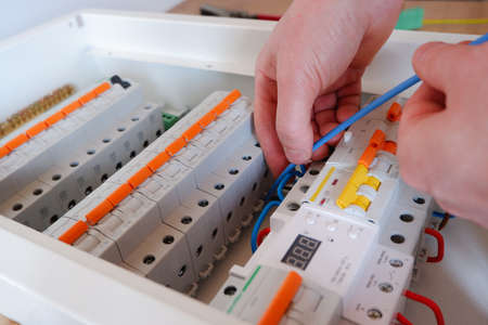 Assembling the electrical panel. The engineer makes the connections of the shield elements with copper wire.の写真素材