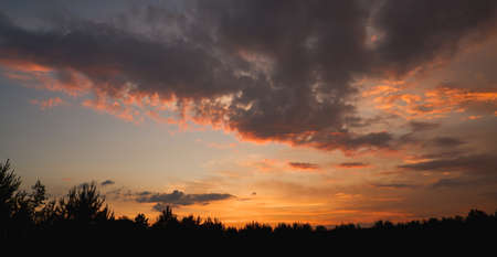 The sky at sunset before bad weather. Low red sunlight illuminates thunderclouds.の写真素材