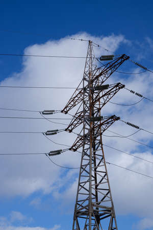 High voltage power line. View of the metal support of the power transmission line against the background of the blue sky.の写真素材