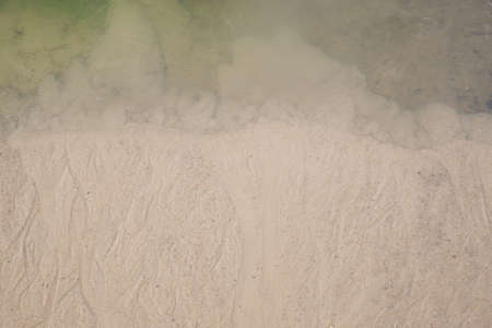 Background blurred by groundwater sandy river bank, first ice on waterの写真素材