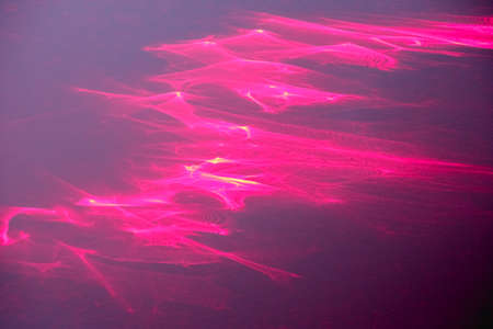 Abstract fractal light background photo. Red, orange, gold light glows, rays, shapes on a dark background. Background photo drawn by breaking laser beams.の写真素材