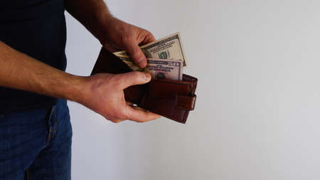 Hand holding a banknote in wallet for financial, accounting and saving money concept. Person holding...